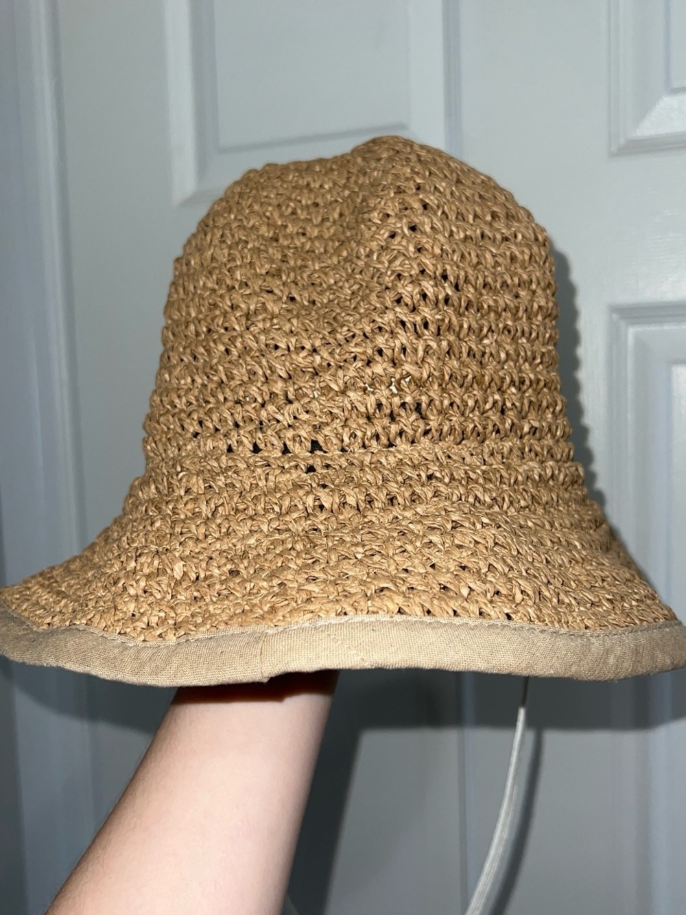 Brown straw mesh bucket hat with adjustable chin strap and foldable brim